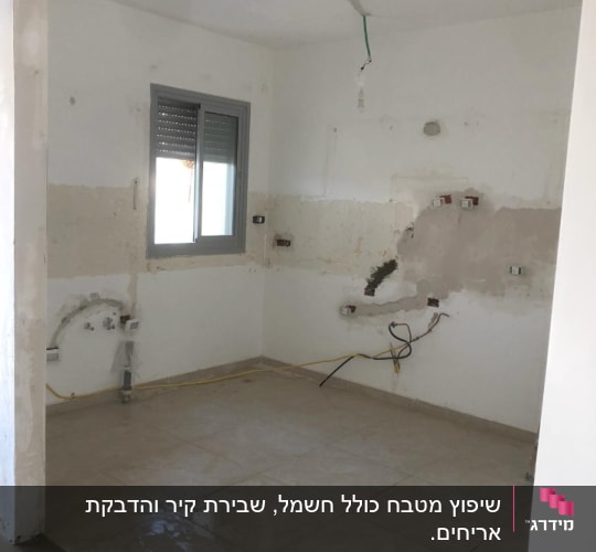 חדר בשיפוץ עם קירות חשופים וחוטי חשמל